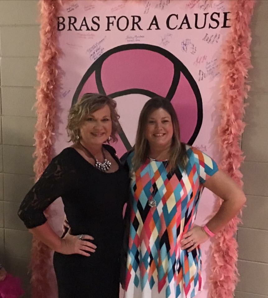 women posing in front of bras for a cause backdrop